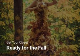 A woman depicting autumn fashion trends, wearing a dress covered in fall leaves.