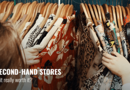 A woman browsing second-hand clothes in a thrift store.