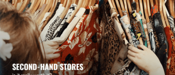 A woman browsing second-hand clothes in a thrift store.